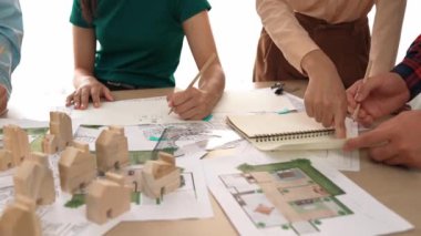 Mimari döküman, ölçüm araçları ve ahşap blokların modern ofiste etrafa saçıldığı masa üzerine planlar yapma konusunda akıllı mimar ve güvenlik mühendisi tartışması. - Yakın çekim. Tanımlama.