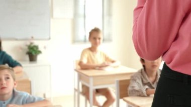 Kafkasya öğretmeninin arka görünüşü farklı öğrencilere karatahta başında durmayı öğretiyor. Profesyonel eğitmen, öğrenciyken sınıf çalışmalarını açıkla ve dikkatlice dinle. Eğitim konsepti. Pedagoji.