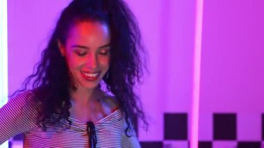 Stüdyoda mor ışıkla sokak dansı yapan İspanyol sokak dansçılarına yakın çekim. Profesyonel sanatçı şık kumaşla enerjik bir hareket sergiler. Çılgın, komik. Yarı vücut. Mutluluk.