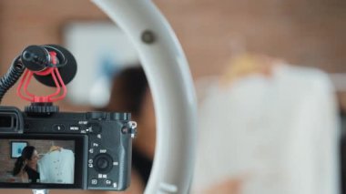 Kadın nüfuzlu kişi video görüntülerini canlı yayınlıyor. Sosyal medya ya da blog. Stüdyo ışıklandırması olan mutlu genç bir kız pazarlama için internet üzerinden yayın yapıyor..
