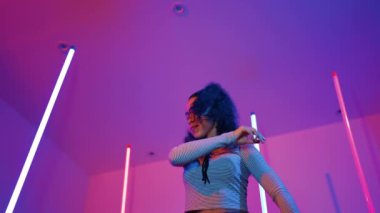 Latin dansçıların kameraya bakıp şehrin pop müziğiyle dans ettiği düşük açılı kamera. Profesyonel çekici hipster, mor veya neon ışıklı hip hop şarkısına geçiyor. Şık bir kumaş. Mutluluk.