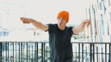 Enerjik hipster, koridorda kendine güvenen bir şekilde poz verirken kameraya bakıyor. Profesyonel koreografın yakın plan portresi sokak dansı yapıyor. Break dans. Açık hava sporu 2024. Hiphop.