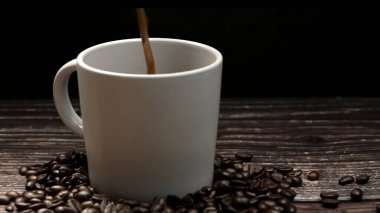 Kahve makinesi fincana siyah arka planda aromatik sıcak kahve dolduruyor. Sıcak kahve ya da espresso beyaz kahve bardağına dökülüyor ve kaynamış suya dökülüyor. Geliştirilebilir.