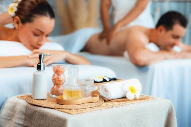 Aromaterapi masajı gündüz atmosferinde ya da spa salonunda bulanık bir kadına odak dekor ve spa aksesuarları kurarak tatil köyünde ya da otel arka planında keyifli aroma spa masajı yapan bir masaj. Sessiz.
