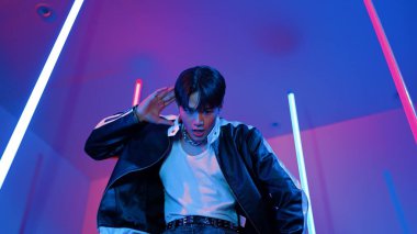 Profesyonel sokak dansçısının sıradan kıyafetlerle kameraya baktığı alçak açılı kamera. Stüdyoda mor ışık altında dururken şehirde pop müzik yapan yetenekli bir sanatçı. Kapatın. Mutluluk.