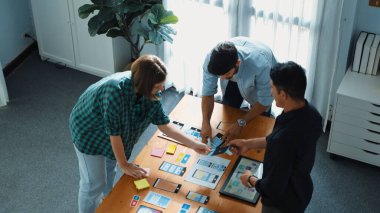 Ux Uo tasarımı ya da çeşitli geliştirme ekipleri ile mobil arayüz kablo tasarımı hakkında akıllı Ui tasarımcı beyin fırtınası ve planlama üst görünümü. Kafkasyalı programcı yürüyor ve toplantıya katılıyor..