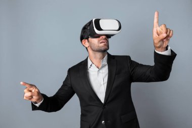 VR gözlük ve takım elbise giyerken veri analizine bakan yetenekli bir iş adamı. Proje yöneticisi görsel gerçeklik gözlüğü ya da kulaklık kullanırken kontrol ediyor ve seçiyor. Yenilik teknolojisi. Sapma.