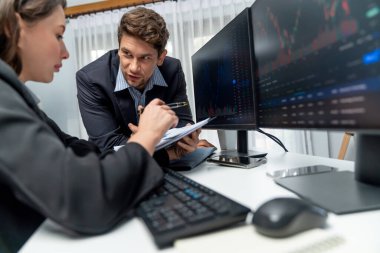 Kağıt raporunda değer istatistik şirketini tartışan iki tüccar dinamik borsa para birimini gerçek zamanlı web sitesi ofisteki bilgisayar ekranlarını çevreledi. Varsayım.