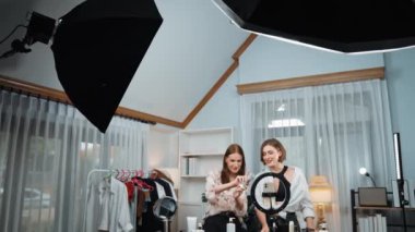 İki kadın nüfuzlu partner sosyal medya veya blog için canlı yayın yapan video klip inceleme derisi çekiyorlar. Kozmetik stüdyosu ışıklandırması olan genç bir kız pazarlama oturumu çevrimiçi yayın yapıyor.