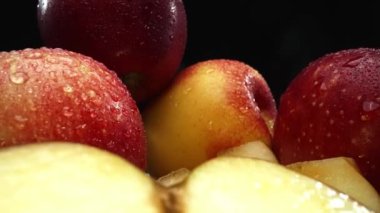 Makrografi, taze elma dilimleri çarpıcı bir siyah arka plana karşı bir kesme tahtasına yerleştirilmiştir. Her yakın çekim elmaların canlı dokusunu ve canlı renklerini yakalar. Geliştirilebilir.