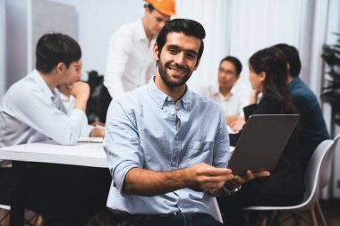 Mühendis ekip lideri portresi çeşitli inşaat mühendisi ve müvekkil gruplarıyla birlikte mimari proje üzerinde çalışıyor, inşaat planını gözden geçiriyor ve toplantı masasında proje oluşturuyorlar. Tedbirli