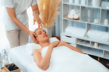 Kafkasyalı kadın stres önleyici kafa masajından ve lüks tatil beldesi ya da otel spa salonundaki modern ışık ortamında yüz güzelliği eğlencelerini şımartmaktan hoşlanıyor. Sessiz.