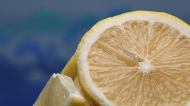 A slice of fresh lemon, bright yellow and vibrantly citric, lies exposed. The flesh, glistening with refreshing juice, reveals its segmented interior. The essence of citrus vibrancy. Comestible. clipart