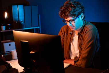 Genç işadamı, Neon Light Modern Ofis 'te yaratıcı bir başlangıç projesi için bilgisayara odaklanıyor. Düşünüyorum da, pazarlama ağı yaratıcıdan pazar kanalı tasarım konseptine çevrimiçi planlama. Toplayıcı.