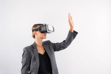 Akıllı iş kadını bir şeye dokunurken VR camına bakar. Takım elbise giyen yetenekli proje yöneticisi ve metaevrene bağlanmak için görsel gerçeklik gözlükleri takıyor. Kısıtlanma.