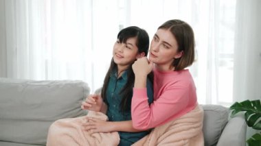 Annesi peri masalı anlatırken, mutlu kız beyaz annelerin kucağında oturuyor. Anne, kızı eve bakıp gülümserken ona sıcak bir şekilde sarılıyor. Aile birlikte vakit geçirir. Pedagoji.