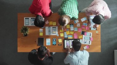 Mobil telefon arayüzü için Ux Ui tasarımı planlarken iş adamlarının yapışkan notlar üzerine yazı yazma fikrine tepeden aşağı bakış açısı. Bir grup yaratıcı tasarımcı kablo prototip tasarımı üzerinde çalışıyor. Cemaat.