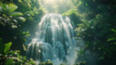 Şelalenin bulanık arkaplanı bir orman göletine dökülüyor. Doğal orman ve güneş ışınlarıyla çevrili güzel bir şelale. Doğa fotoğrafçılığı. Doğal sükunet konsepti. Poster için tasarım. Aktar.