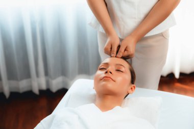 Kafkasyalı kadın stres önleyici kafa masajından ve lüks tatil beldesi ya da otel spa salonundaki modern ışık ortamında yüz güzelliği eğlencelerini şımartmaktan hoşlanıyor. Sessiz.