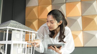 Tablet kontrol evi modelini kullanan güzel bir proje yöneticisi. Mimar mühendisinin portresi tabletteki veri analizini kullanarak bina inşaatını denetliyor. İş inşaat konsepti. Yönlendirici.