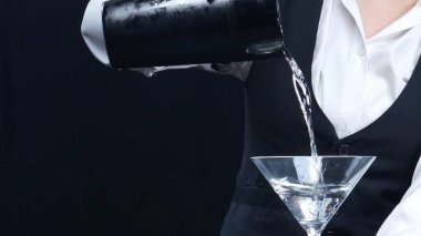 Makrografi, yetenekli bir barmenin martini bardağını dramatik siyah bir arka plana nazikçe döken ellerine tanık olun. Her bir kokteyl yakın çekim. Geliştirilebilir.