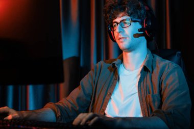 Stresli genç oyun flaması takımı, Esport ile çevrimiçi olarak bilgisayar üzerinde daha sert oyun seviyesine odaklanmış ve neon aydınlatma odasında strateji planı uygulamak için sürpriz yüz ifadesiyle kazanmayı denemiştir. Toplayıcı.