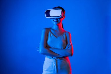 Akıllı kadın, metaevrene bağlı, fütürist siber uzay teknolojisine sahip VR kulaklık takıyor. Zarif kadın sanal alana bakarken kendine güvenerek poz veriyor. Halüsinasyon.