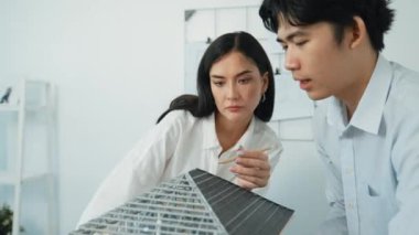 Ev inşaatını işaret edip tartışırken mimari teçhizat kullanarak birlikte çalışan profesyonel mühendis ekibinin yakınlaşması. Yaratıcı karar ve takım çalışması konsepti. Tertemiz..