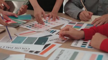 Grafik tasarımı için beyin fırtınası yapan ve renk seçimi yapan tasarımcı ekibinin yavaş çekim çekimi veya tasarım bürosunda krom danışmanlığı için danışmanlık isteyen bir müşteri. Değiştirilmiş