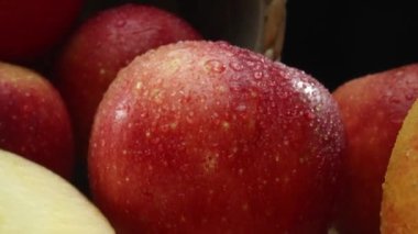 Makrografi, taze elma dilimleri çarpıcı bir siyah arka plana karşı bir kesme tahtasına yerleştirilmiştir. Her yakın çekim elmaların canlı dokusunu ve canlı renklerini yakalar. Geliştirilebilir.