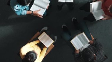 İncil 'i okuyup, kucağında İncil' le daireler çizerek otururken en tepeden aşağı dua manzarası. İnanç, güven ve umut ve sükunetle çalışırken farklı insanların kitaba bakışları. Sempozyum.