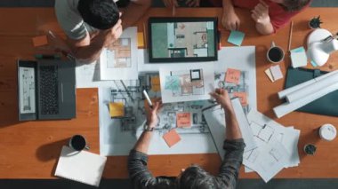 Toplantıda tablet kullanarak iç mimar planlama binasının üst hava görüntüsü. Bir grup mimar mühendis, fikir üretme ve ev yapısını tasarlama işini yönetime sunarken. Sempozyum.