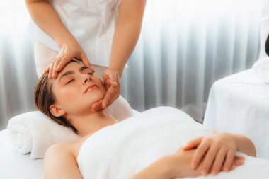 Kafkasyalı kadın stres önleyici kafa masajından ve lüks tatil beldesi ya da otel spa salonundaki modern ışık ortamında yüz güzelliği eğlencelerini şımartmaktan hoşlanıyor. Sessiz.