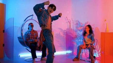 Çok kültürlü bir arkadaş kürsüde otururken Asyalı yetenekli bir dansçı modern müziğe geçiyor. Profesyonel dansçı, hipster takımı tezahürat yaparken ve desteklerken enerjik adımlar atıyor. Mutluluk.