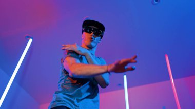 Beyaz dansçının gösterişli gözlükler taktığı ve break dans yaptığı alçak açılı kamera. Çekici adam kendinden emin bir şekilde kameraya bakarken enerjik bir performans ve hareket gösterdi. Mutluluk.