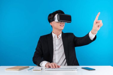Asyalı işadamı dokunmatik ekran hologram monitörünü fütüristik metaevrende analiz ederek yenilik teknolojisi iş dünyası sanal gerçekliği mavi telif alanını izole ediyor. Entrika.