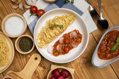 Lezzetli yiyecekler, ev yapımı spagetti, kıymalı domates sosu ve fesleğen fırlatma elementleri, şef masası dekoratif baharatlarla servis ediliyor. Varsayım.