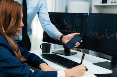 Kâr değeri değeri oranı online web sitesi uygulamasını ev ofisinde analiz etmek için notlar yazan kadınlara telefonda dinamik borsa verilerini gösteren bir işadamı eli kesilmiş. İnfobahn.