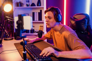 Oyun kanalı, online oyun oynayan akıllı flamalı oyun sunucusu, kulaklık takan, neon ışıklandırma odasındaki takım oyuncusuyla akıllı telefondan canlı yayında konuşan izleyiciler. Bireysel.