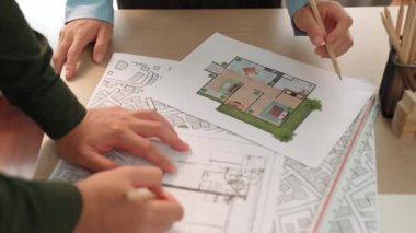 Mimari ekipmanlarla toplantı masasında ev tasarımı üzerine profesyonel mühendis ekibi tartışması ve modern ofiste bina planı dağılımı. Eline odaklan. - Yakın çekim. Tanımlama.