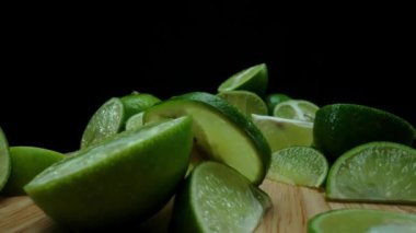 Yakın plan, canlı bir dilim taze kireç kırsal bir ahşap kesme tahtasının üzerinde duruyor. Tazelik ve canlılık yayıyor. Kesme tahtasına konmuş yeşil limon diliminin yarı saydam zarları. Geliştirilebilir.