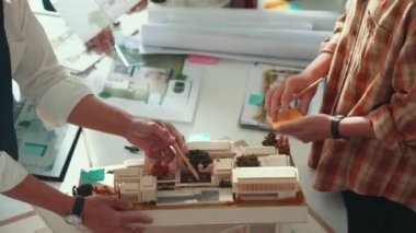 Akıllı mimar ya da inşaat mühendisi bina yapısı fikrini not edip plana yapıştırıyor. Yöneticinin çeşitli meslektaşları ve ev planlarıyla birlikte çalıştığı hava görüşü. Hizalama.