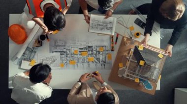 Becerikli mühendis ekibinin ev inşaatından bahsedişinin en alt görüntüsü. Mimar ya da tasarımcı grubunun planlar hakkında beyin fırtınası yapmak için tartışan ve yazan hava görüşü. Hizalama.