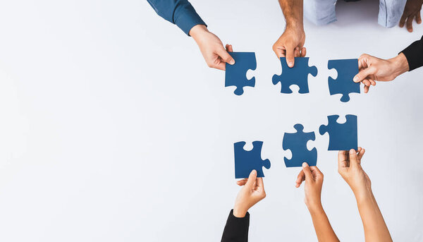 Top view panorama banner of business team joining jigsaw puzzle together over meeting table symbolize business partnership and collective unity teamwork in problem solving solution. Prudent