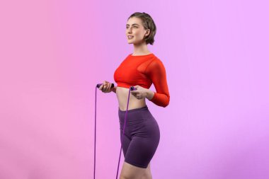 Vücut uzunluğunun tamamı atletik ve sportif genç bir kadın tarafından izole edilmiş arka planda ip atlarken çekildi. Sağlıklı aktif ve vücut bakımı yaşam tarzı.