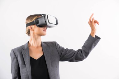 Profesyonel kadın lider programa dokunuyor ya da sanal gerçeklik gözlüğü kullanırken çalışıyor. Yetenekli iş kadını, görsel gerçeklik gözlüğü takarak metaevrene bağlanırken sistemi işaret ediyor. Kısıtlanma.