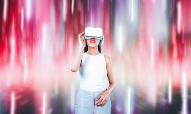 Beyaz VR kulaklık takan bir kadın ve beyaz kolsuz bağlantı metaverse, gelecekteki teknoloji siber uzay topluluğu yaratıyor. Etrafında soyut bir ışık görmek hoşuna gidiyor. Halüsinasyon.