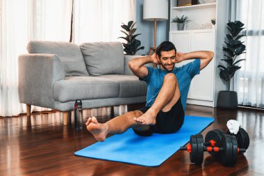 Atletik ve sporcu adam, evde vücut egzersizi yaparken spor ve spor yaşam tarzına uyum sağlamak için spor minderinde çatırdıyor. Gaiety ev egzersizi antrenman konsepti.