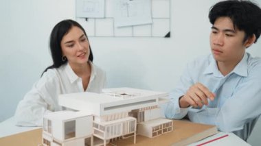 Profesyonel akıllı iş birliği mühendisi mühendis ekibi modern ofisteki ev yapısını planla kontrol ederken genç ve güzel proje yöneticisi not alıyor. Yaratıcı tasarım konsepti. Tertemiz...