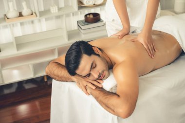 Kafkas erkek müşteri stres önleyici spa masajının keyfini çıkarıyor ve lüks otel veya oteldeki gündüz açık hava ortamında güzellik derisi eğlencesi ile şımartıyor. Sessiz.